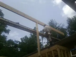 Carpenter setting a ridge beam over a new addition frame — Ice Dam Removal by Roofing Brothers in Brainerd
