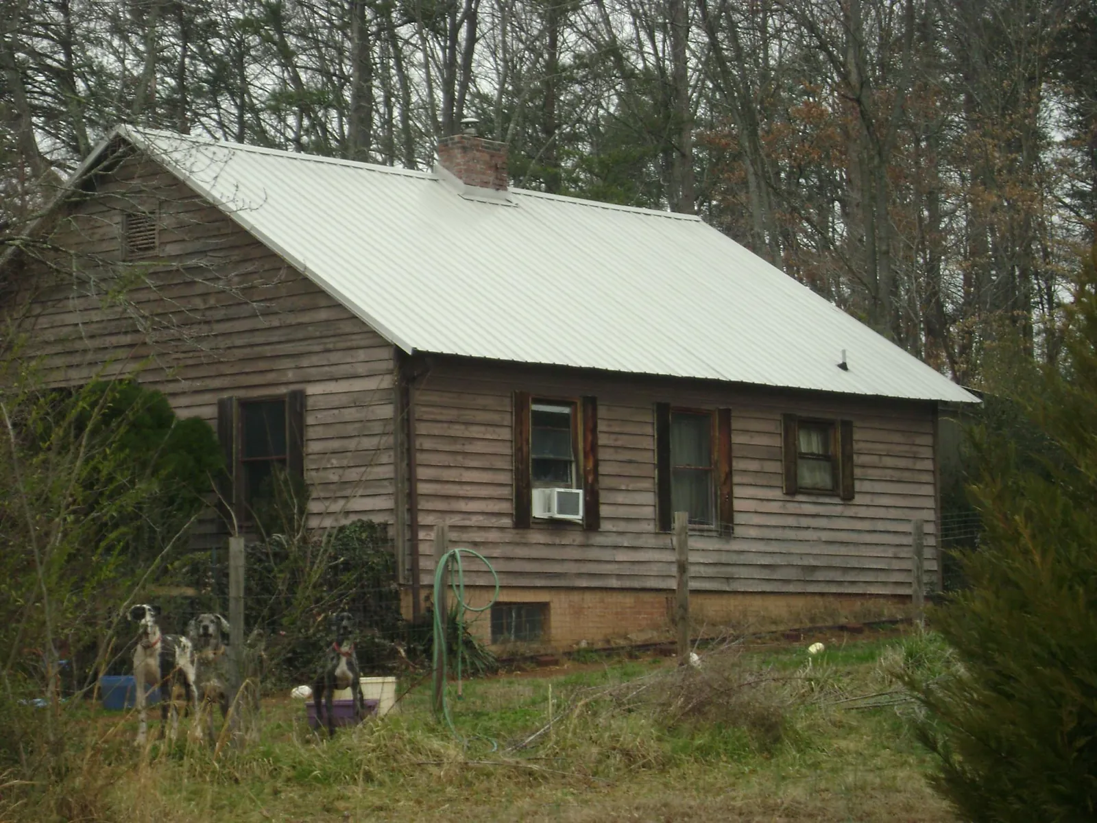 White metal roof on an old wood sided farmhouse, from a Metal Roof Installation job in Brainerd